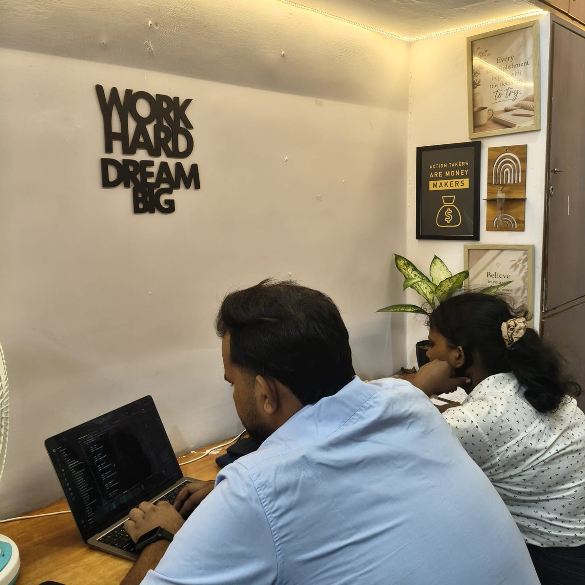 SoftFYR team working under the Work Hard Dream Big sign